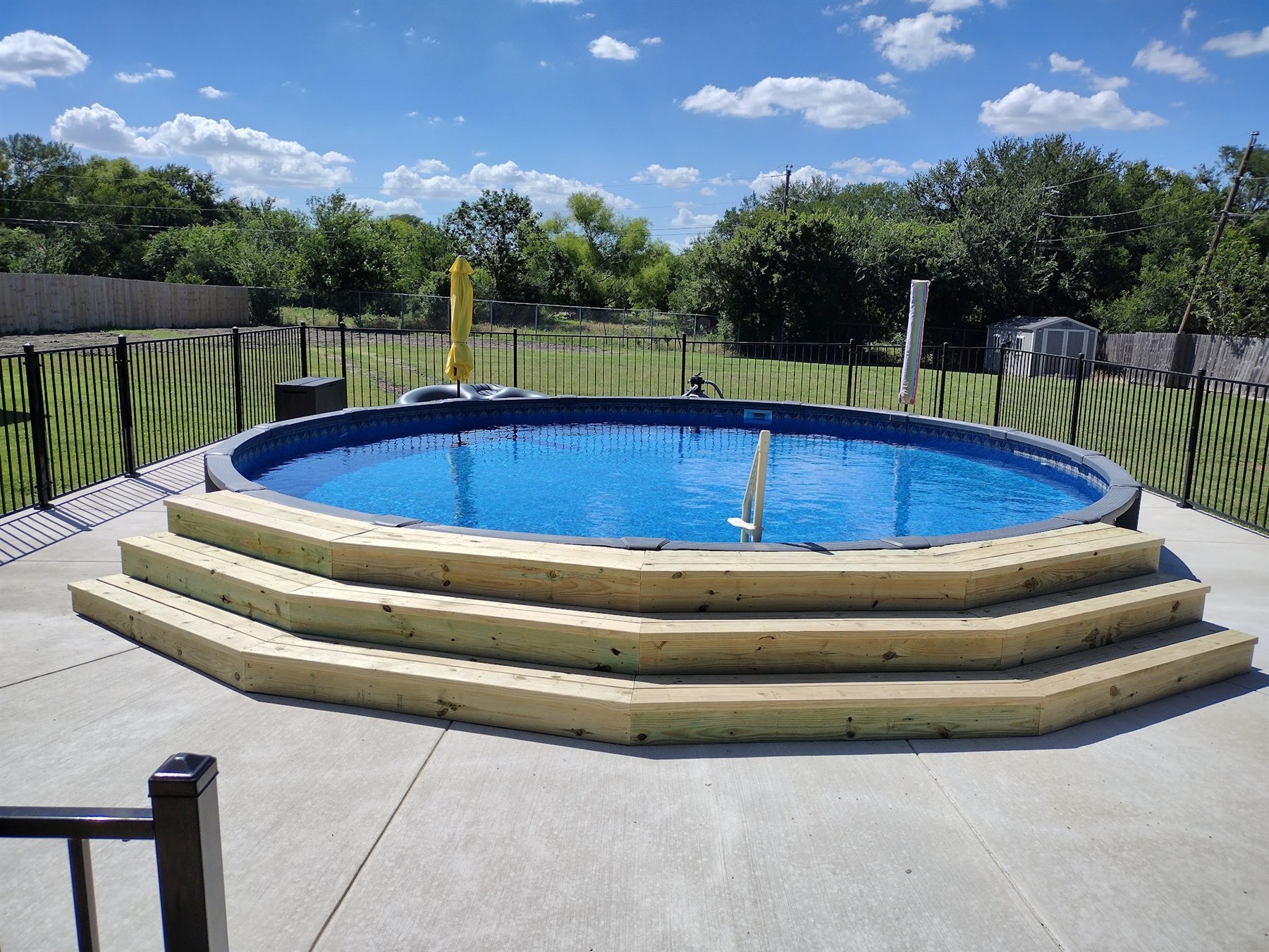 Wraparound wood deck steps built around an above-ground pool